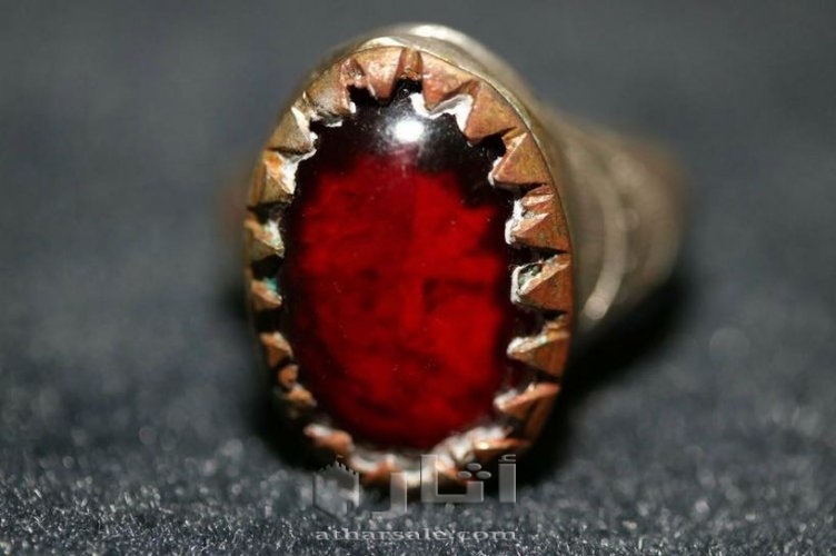 خاتم قديم عليه حجر احمر به وجه يتحرك يمين ويسار ويفتح فمه
