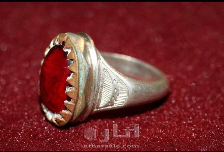 خاتم قديم عليه حجر احمر به وجه يتحرك يمين ويسار ويفتح فمه