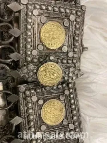 An old silver belt containing a collection of a quarter riyal dated 1354