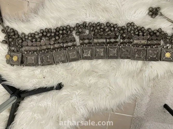 An old silver belt containing a collection of a quarter riyal dated 1354