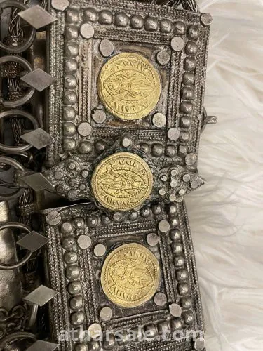 An old silver belt containing a collection of a quarter riyal dated 1354