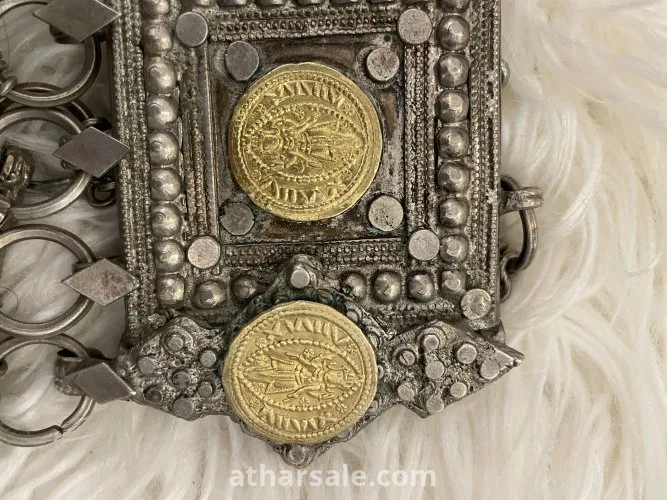 An old silver belt containing a collection of a quarter riyal dated 1354