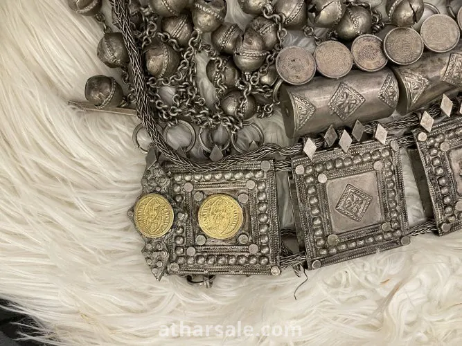 An old silver belt containing a collection of a quarter riyal dated 1354