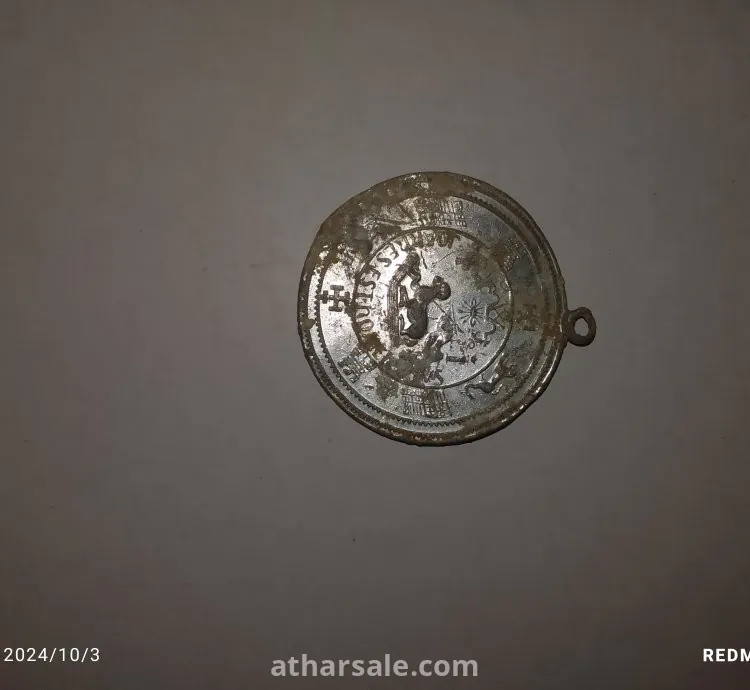 An old silver pendant and coin dating back to Puerto Rico