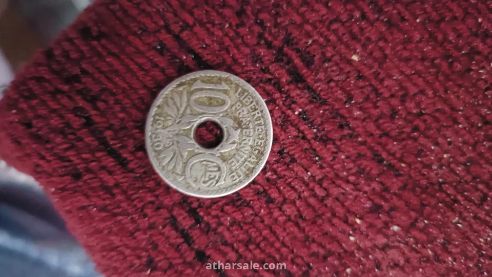 العملة التي تظهر في الصورة هي عملة 10 سنتيم فرنسية قديمة، تُعرف باسم "نوع لينداور" (Lindauer type).